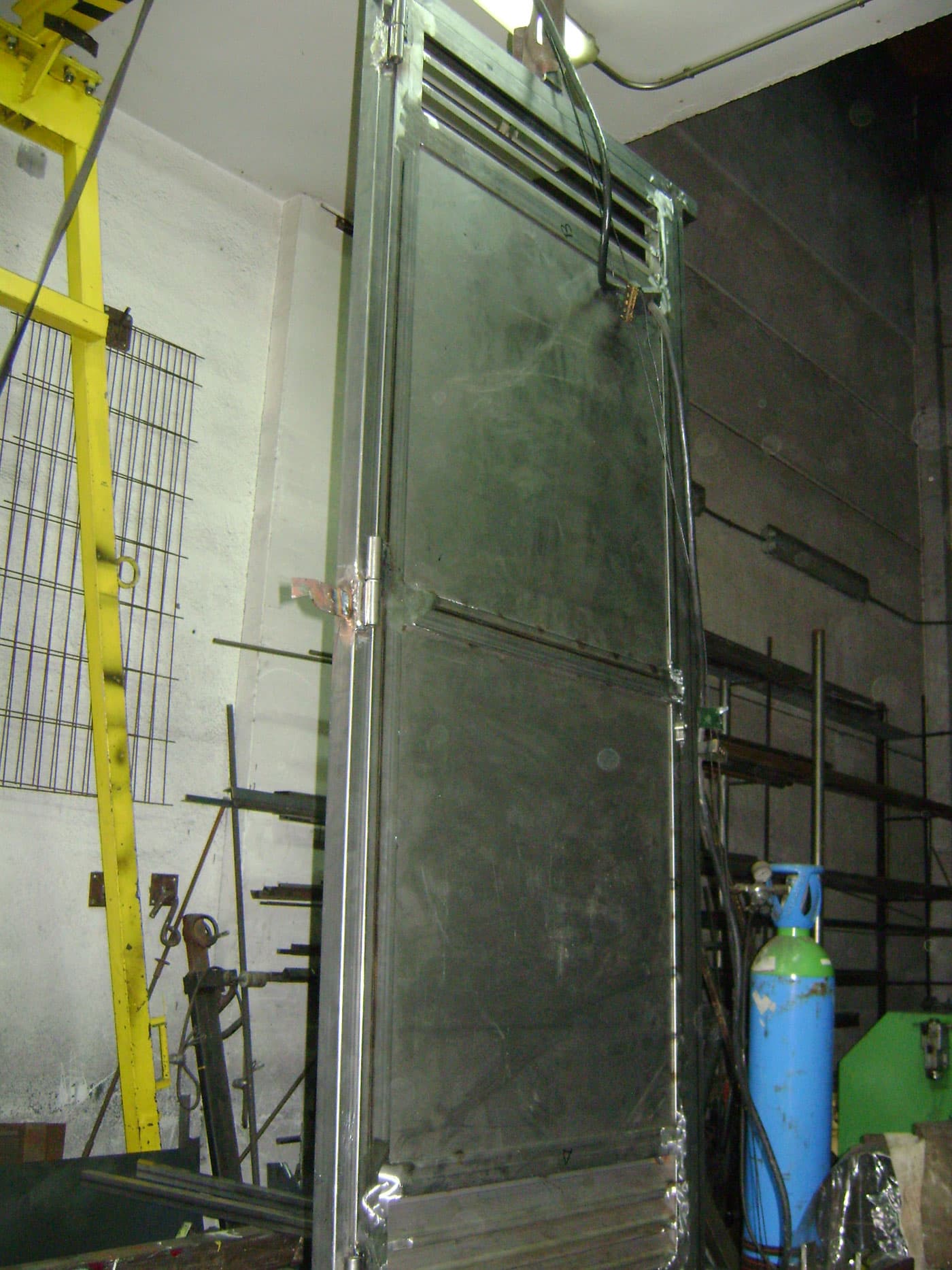 Puerta peatonal de cuarto de calderas, lacada en RAL 3020